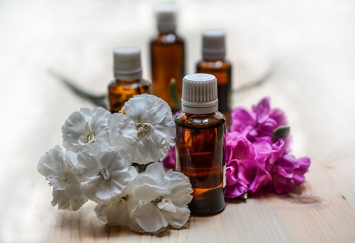 bottles of essential oils for allergies with flowers around them
