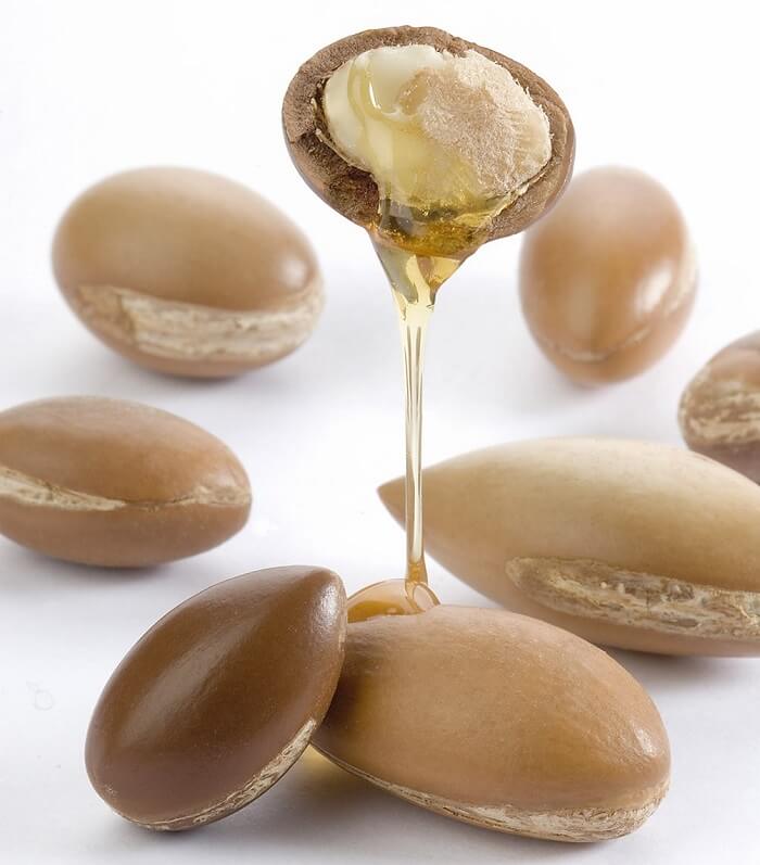 a bunch of argan nuts and oil coming out of one
