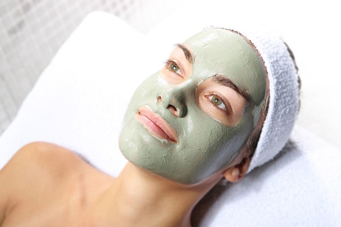 a woman with a green acne mask