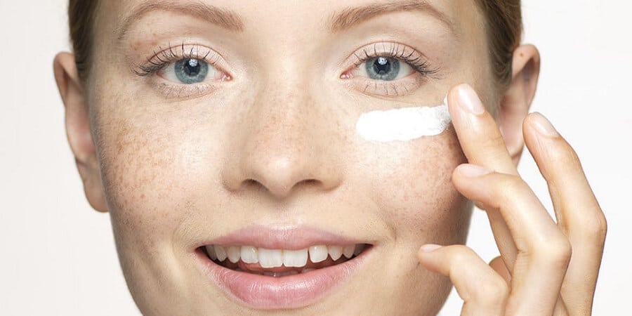 1 woman applying eye cream