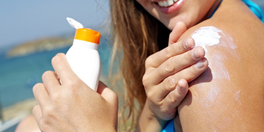 1 woman applying sunscreen