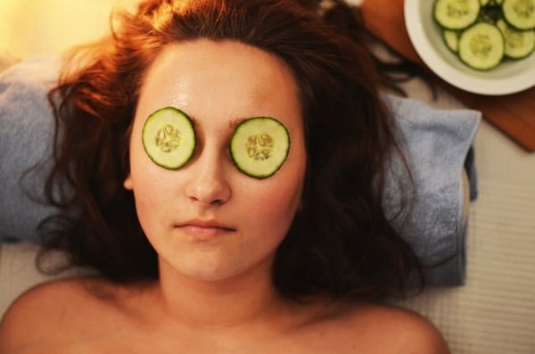 Woman with cucumber slices