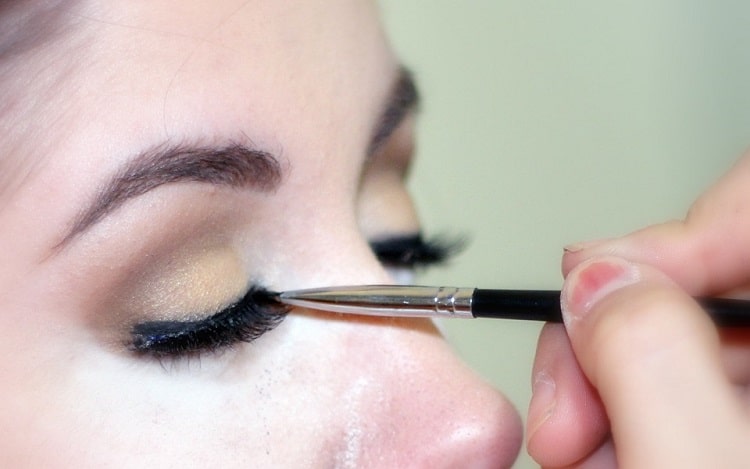 cosmetician applying makeup on model