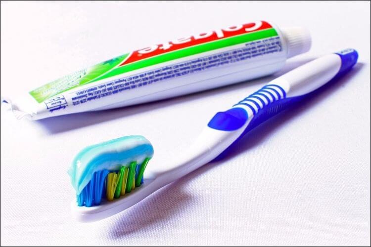 Toothbrush with toothpaste next to toothpaste 
