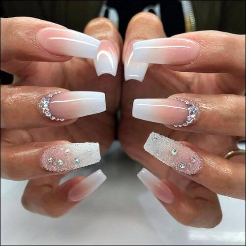 Focus on a woman's hands with ombre nails in white and pink