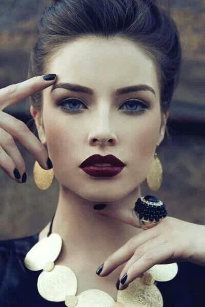Woman wearing a dark color on the lips paired with groomed eyebrows and simple eyeshadow