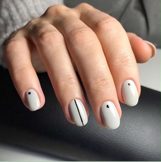 close up on left hand with white simple manicure