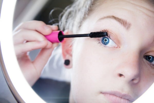 woman applying mascara on her lashes