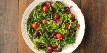 vegetable salad in whit plate on wooden table 861x584